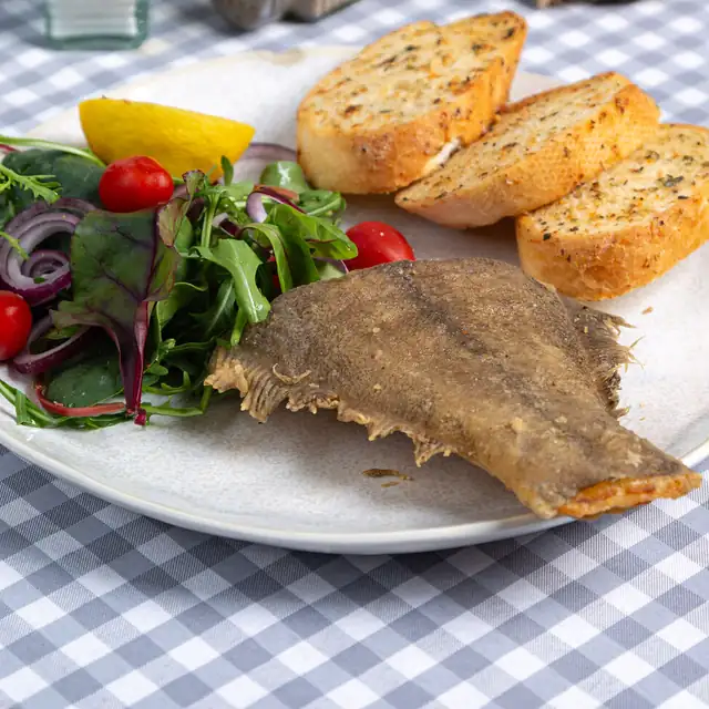 Smażony halibut z grzankami czosnkowymi, sałatą i cytryną