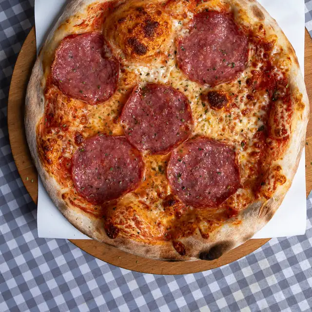 Pizza salami na stole w kratkę