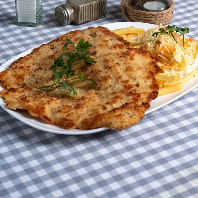 Duży kotlet schabowy z frytkami i natką pietruszki